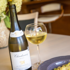 white labeled bottle beside wine glass on table